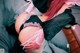 A woman in a black and pink lingerie laying on a bed.