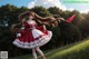 A girl in a red and white dress standing in a field.