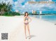 A woman in a bikini standing on a beach.