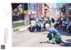 A woman crouching down on the ground in front of a crowd of people.