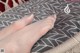 A close up of a woman's feet on a pillow.