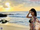 A woman standing on a beach next to the ocean.