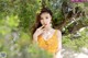 A woman in a yellow dress posing for a picture.